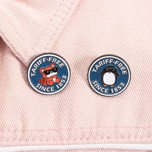 Détail de broches émaillées pingouin et panda roux sur denim rose avec texte rétro