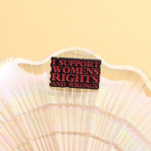 Macro shot of rectangular enamel pin with I Support Womens Rights and Wrongs slogan