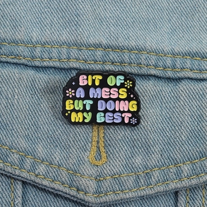 Rainbow letter enamel brooch on denim jacket with Bit of a Mess But Doing My Best quote