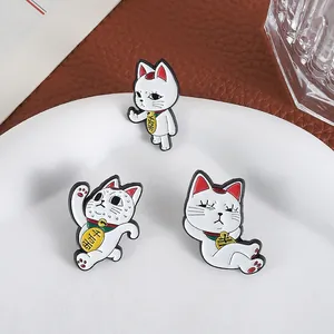 Detailed view of three white lucky cat enamel pins with different funny poses and gold coins