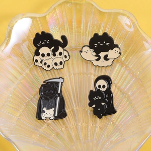 Detail of gothic black cat enamel pins featuring grim reaper and skull designs