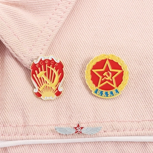 Macro-opname van drie USSR-metalen pinnen op een roze gestructureerde denimstof