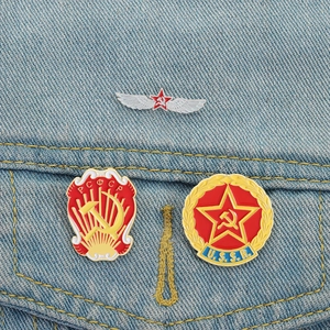 Lot de trois pin's rétro soviétiques avec marteau et faucille sur veste en jean