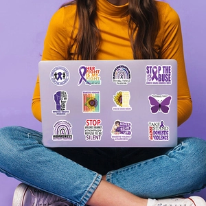 Domestic violence awareness stickers with purple ribbons displayed on a laptop back
