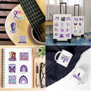 Close-up of domestic violence awareness stickers applied on laptop and guitar surfaces