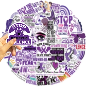 Close-up of hand holding a purple stop domestic violence waterproof vinyl sticker