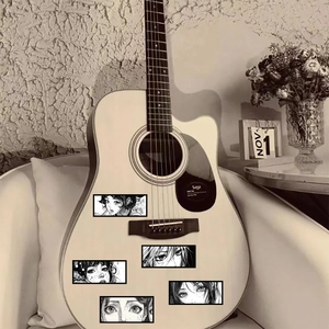 Close-up of anime girl eye stickers on a white acoustic guitar for personalized decoration