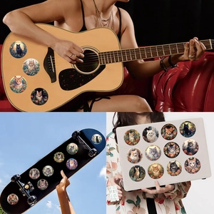 Detailed application of round cartoon cat stickers on guitar and laptop surfaces