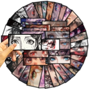 Close-up showing anime eye stickers for guitar and laptop with one held in hand
