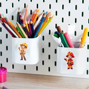 Detail of white wall-mounted stationery organizers with fireman and worker cartoon patterns