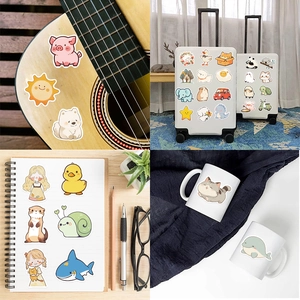 Détail des autocollants cartoon imperméables sur guitare, valise et surfaces de carnet