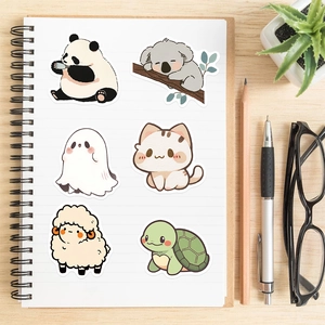 Set de stickers d'animaux mignons sur carnet avec crayon et lunettes sur bureau