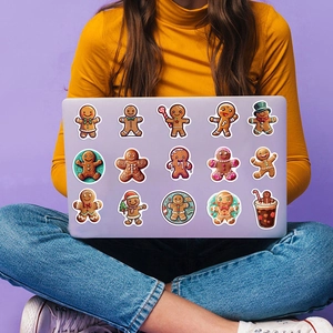 Cartoon gingerbread man stickers on a laptop featuring various cute holiday designs