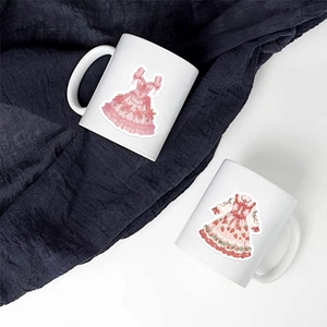 Détail de tasses en céramique blanche avec illustrations de robes Lolita et motifs dentelle