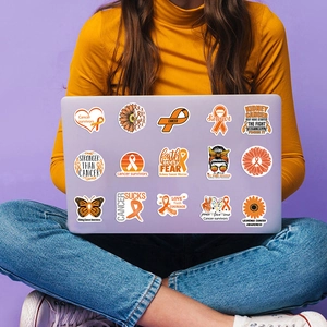 Close-up of leukemia awareness stickers on a purple laptop with orange ribbon designs