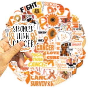 Close-up of Stronger Than Cancer orange ribbon sticker on a blurry background