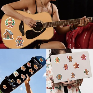 Detail showing waterproof gingerbread man stickers applied to guitar and laptop surfaces