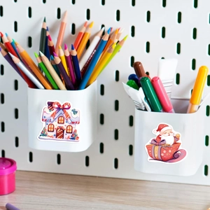 Close-up of Christmas stickers featuring Santa and a gingerbread house on a storage box