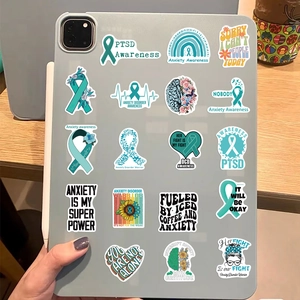Mental health awareness stickers featuring teal ribbons and floral motifs on a laptop