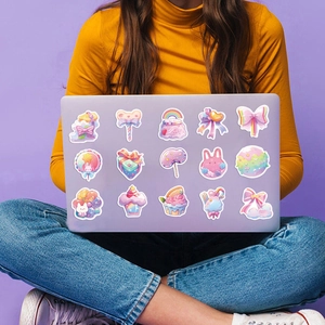 Détail d'autocollants bonbons mignons sur un ordinateur portable aux couleurs pastel