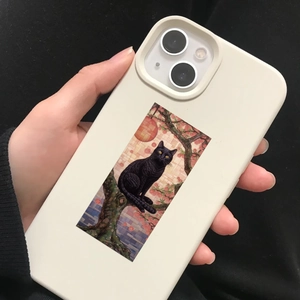 Dettaglio della custodia iPhone color crema con gatto nero e decorazione floreale rosa