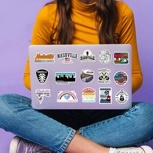 Nashville stickers on a laptop held by a person in a lifestyle setting