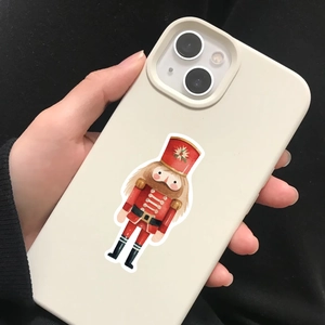 Close-up of nutcracker soldier print on a cream silicone phone case held in hand