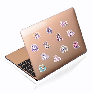 Close-up of 12 colorful cartoon unicorn stickers on a rose gold laptop surface