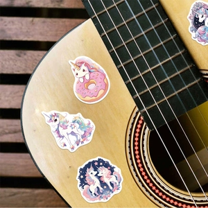 Waterproof unicorn vinyl stickers applied to a wooden acoustic guitar surface