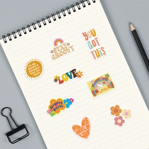 8 pegatinas retro groovy impermeables con frases motivadoras sobre un cuaderno