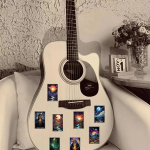 Close-up of tarot stickers in fantasy art style applied on a white matte acoustic guitar