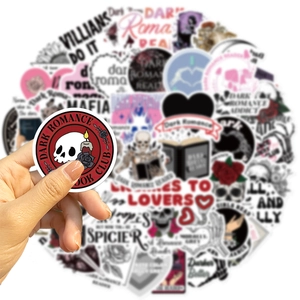 Macro shot of a hand holding a Dark Romance Book Club sticker with gothic aesthetic designs