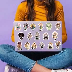 Detalle de pegatinas de niñas de dibujos animados en una funda de laptop morada para DIY