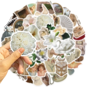 Close-up of vintage flower stickers showing white rose patterns and DIY crafting details