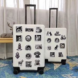 Close-up of black and white hand-drawn animal stickers on white suitcases in a home setting