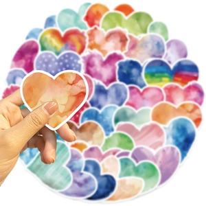 Gros plan d'une main tenant un autocollant cœur en aquarelle colorée au style artistique
