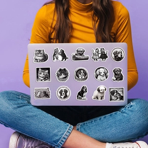 Detail of black and white sketch pet stickers on a purple laptop with a lifestyle background