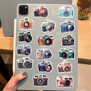 Detailed view of vintage camera stickers on a tablet over a wooden desk background
