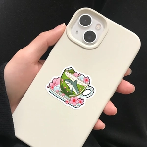 Detail of waterproof INS style shark and matcha tea sticker applied to a smartphone back