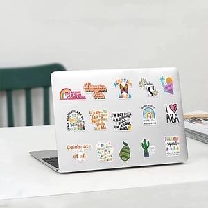 Detail of ABA therapist vinyl stickers applied to a silver laptop on a white desk