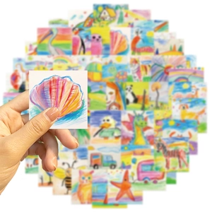 Close-up of a hand holding a colorful seashell sticker from a children's doodle set
