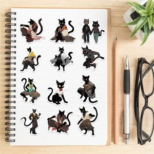 Vue de dessus d'autocollants de chats noirs anthropomorphes sur un carnet