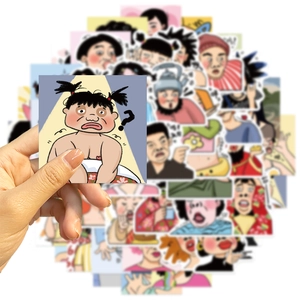 Primo piano di un adesivo a fumetti originale tenuto sopra una pila di decalcomanie DIY
