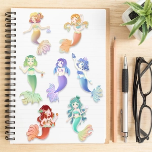 Sept autocollants de sirènes de dessin animé sur un carnet blanc avec de la papeterie