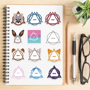 Flat lay of Therian animal ear stickers with Theta-Delta symbols on a white notebook