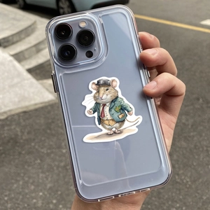 Hand holding a clear iPhone case with a cute suited cartoon mouse character on a street
