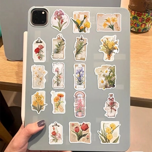 Close-up of vintage flower stickers applied on a tablet case over a wooden desk