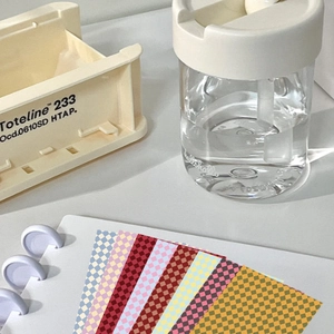 Close-up of colorful checkerboard DIY decorative cards and a purple ring binder notebook