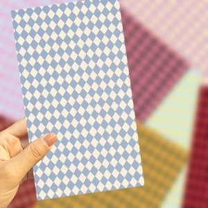 Macro detail of hand holding blue and white harlequin pattern DIY decorative sticker