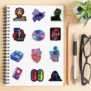 Flat lay of 12 cyberpunk aesthetic stickers on a notebook for DIY laptop decoration